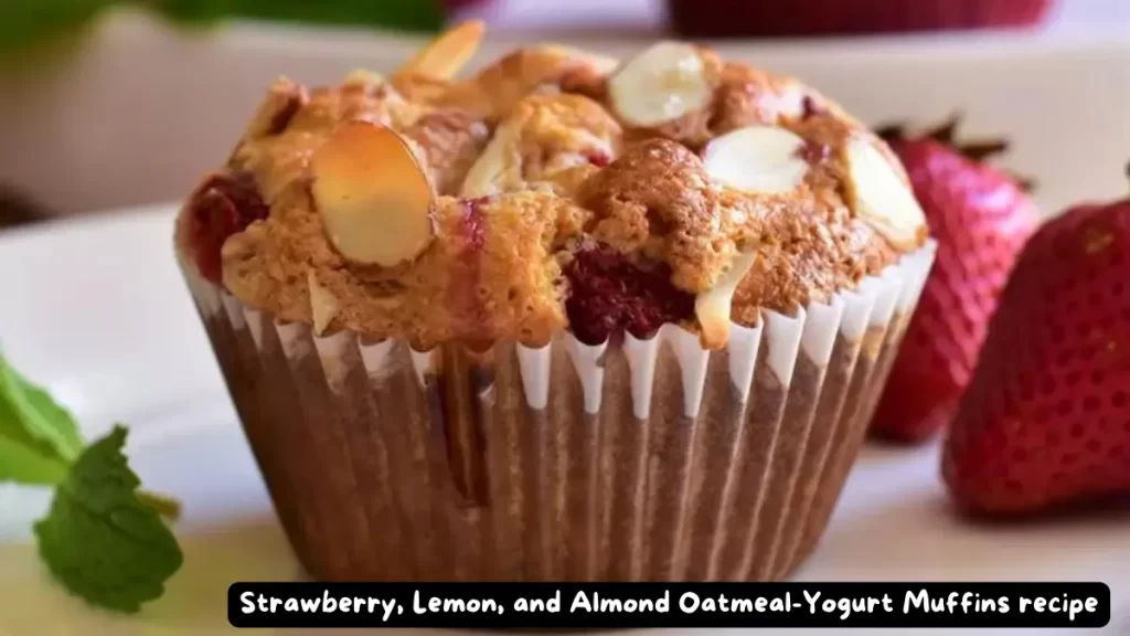 Close-up of a freshly baked strawberry, lemon, and almond oatmeal-yogurt muffin with sliced almonds on top.