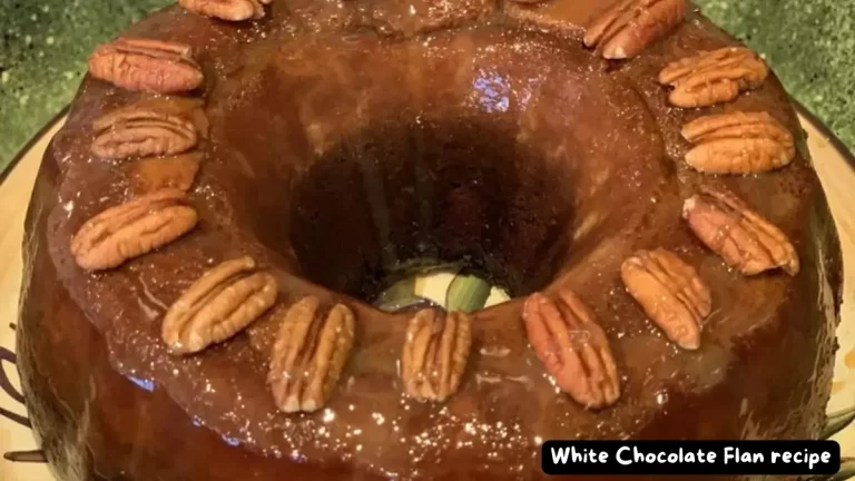 A rich White Chocolate Flan topped with pecans, served on a round plate, showing its smooth caramel glaze and nutty garnish.