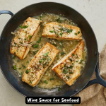 A bowl of rich white wine sauce garnished with fresh parsley, perfect for seafood dishes.