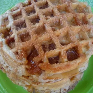 Golden, crispy Churro Apple Pie Waffles topped with cinnamon sugar and apple slices.