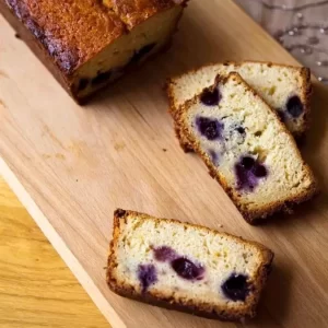 A freshly baked Luscious Lemon and Blueberry Loaf Cake garnished with blueberries.