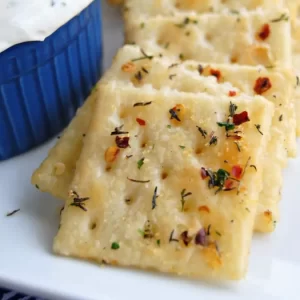 A close-up of golden spicy crackers made with Ranch seasoning and red pepper.