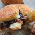 Golden churro donut holes filled with melted chocolate, rolled in cinnamon sugar.