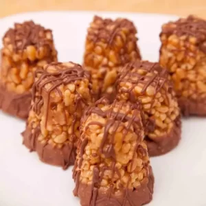 A close-up of gluten-free toffee crispie treats drizzled with chocolate.