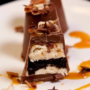 A luxurious vanilla and honeycomb cheesecake encased in chocolate with an Oreo crumb layer and toffee fudge drizzle.